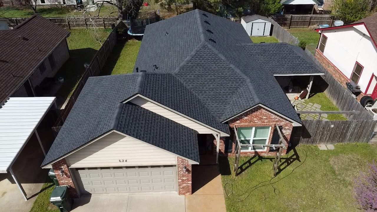 Completed multi-pitch shingle roof on brick home